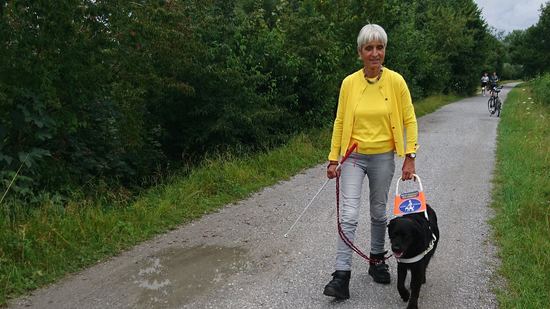 Frau mit Blindenhund im Park