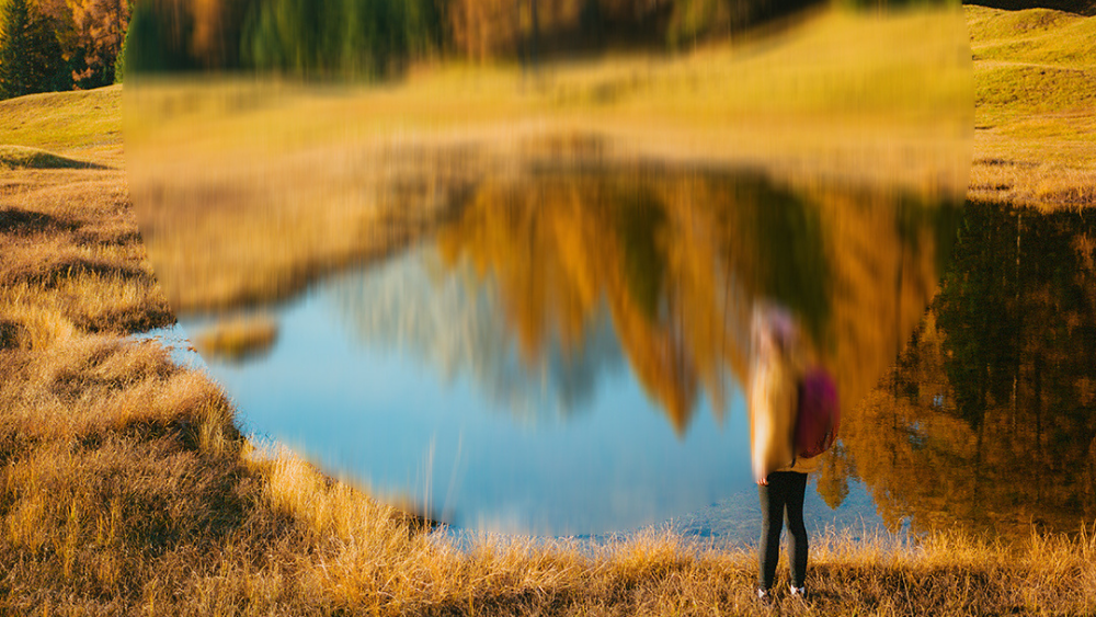 Landschaftsbild mit See und Wald, in der Mitte unscharf