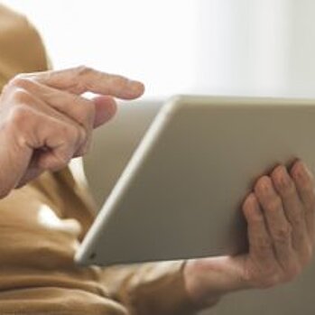 Nahaufnahme von Händen, die ein Tablet halten