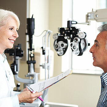 Ein Mann im Arztgespräch mit einer Augenärztin