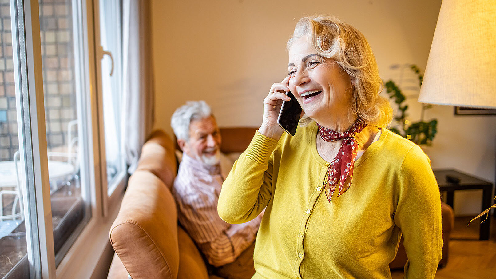 Frau im Wohnzimmer am Telefon 