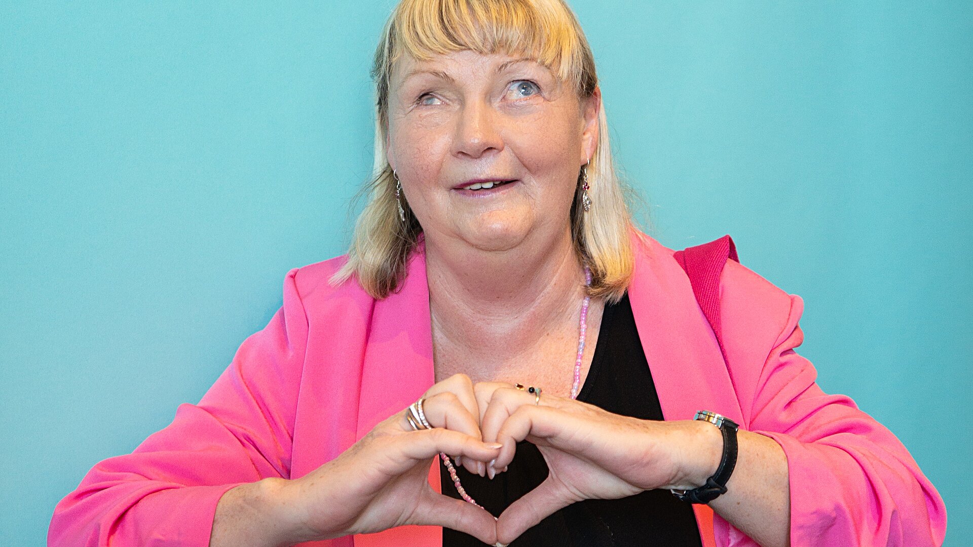 Netzhautpatientin zeigt Herz-Geste 